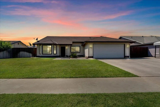a front view of a house with a garden and yard