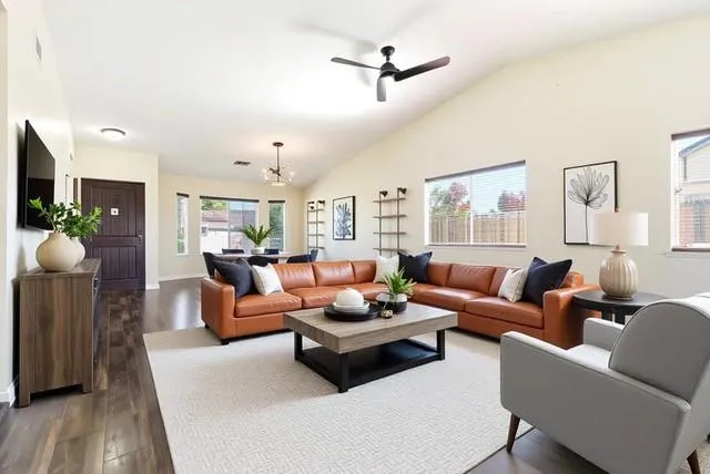 a living room with furniture kitchen view and a wooden floor