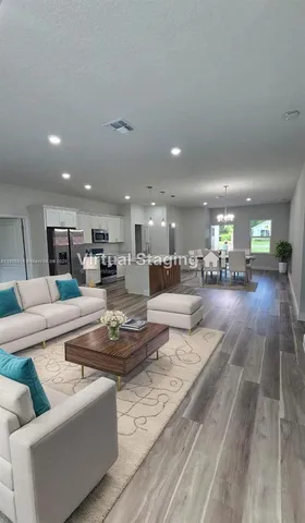 a living room with furniture and kitchen view