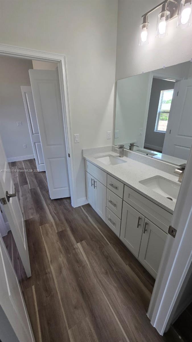 16855 Southwest 18th Avenue Road, Unit 16855 Ocala, FL 34473 - Photo 7 of 16 a bathroom with a granite countertop sink a mirror and a vanity