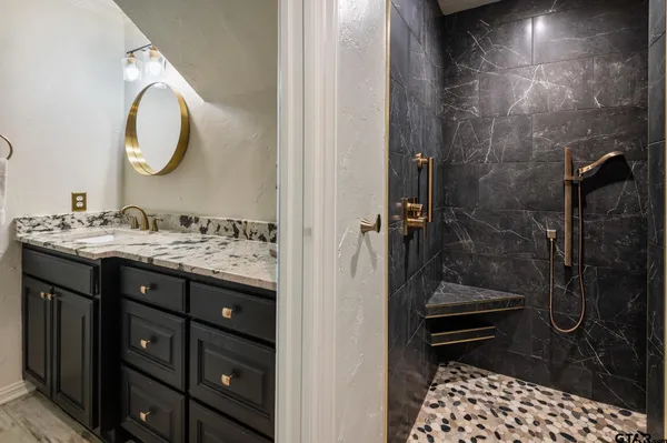 a bathroom with a sink a mirror and a shower