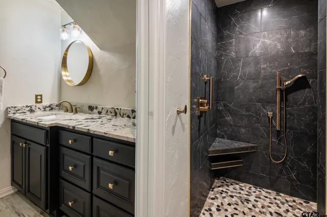 a bathroom with a sink a mirror and a shower