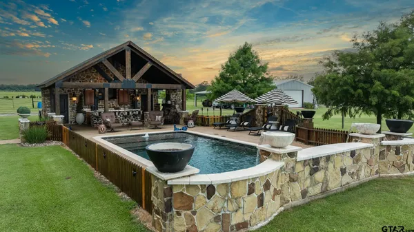 a view of a house with swimming pool and sitting area