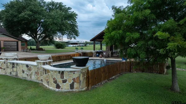 a view of an outdoor kitchen with a table and chairs