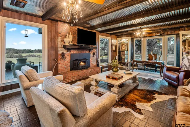 a living room with furniture a flat screen tv and a fireplace