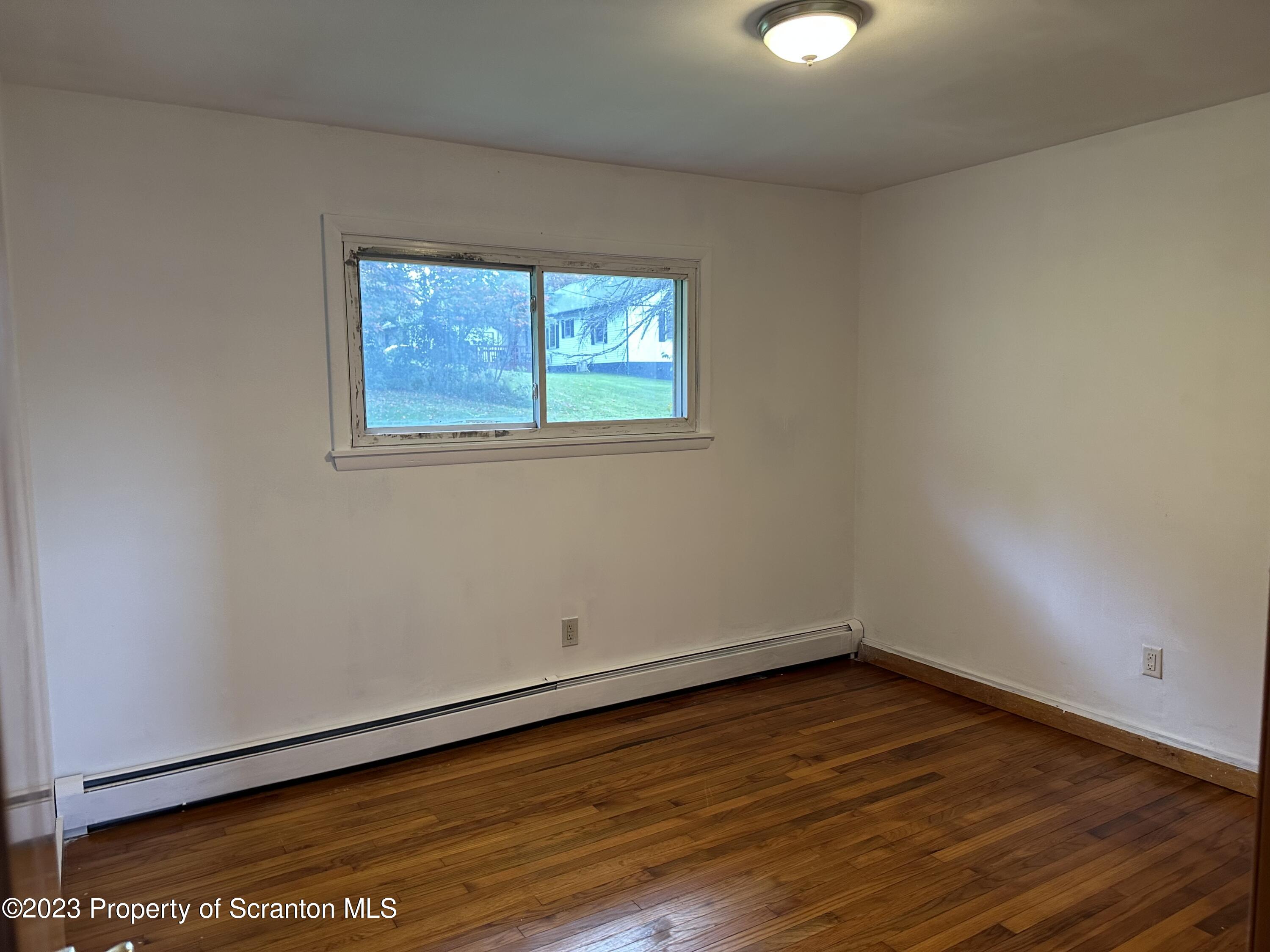 514 Morse Avenue Simpson, PA 18407 - Photo 5 of 9 a view of an empty room with wooden floor and a window