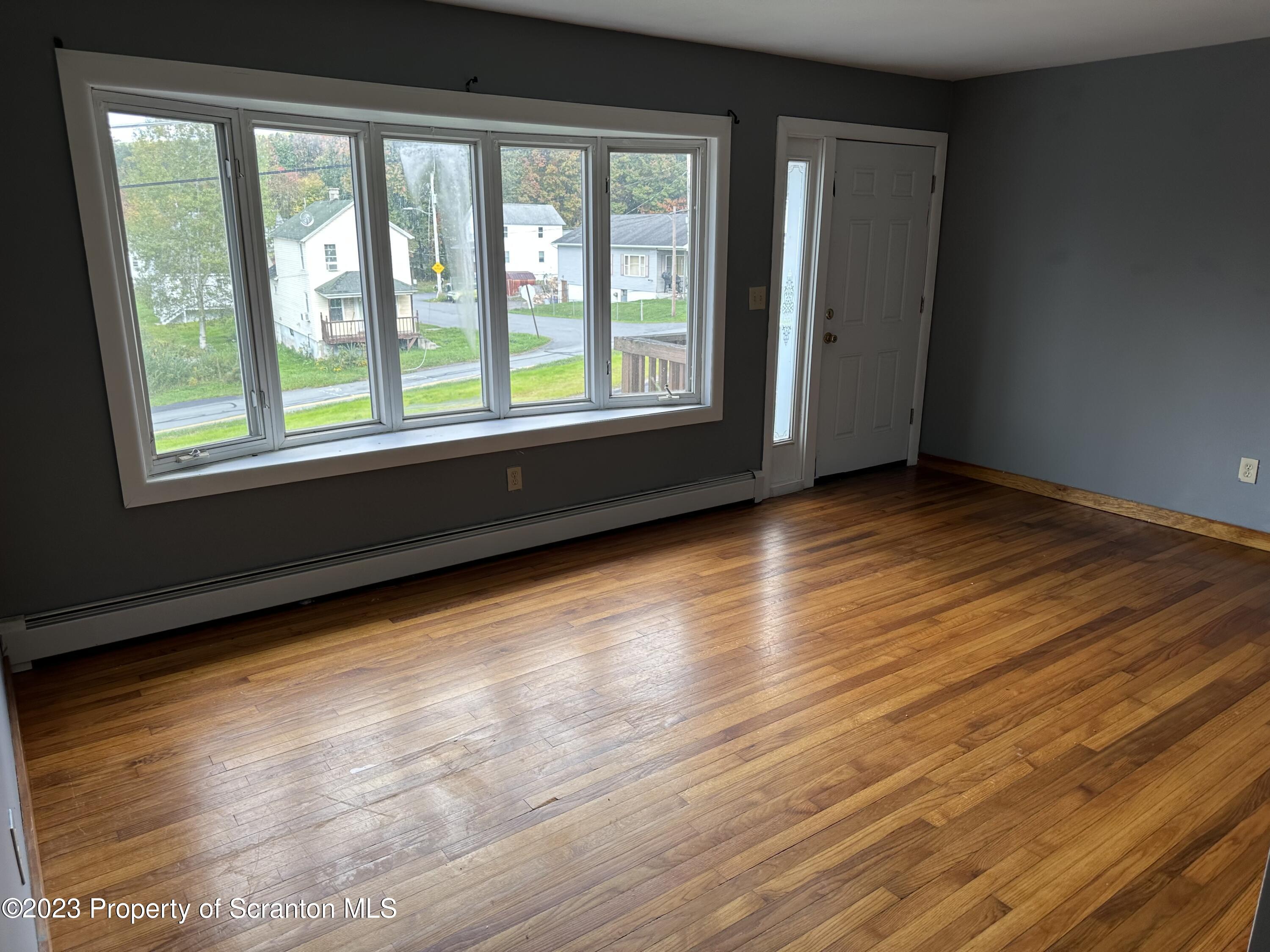 514 Morse Avenue Simpson, PA 18407 - Photo 8 of 9 a view of an empty room with wooden floor and a window