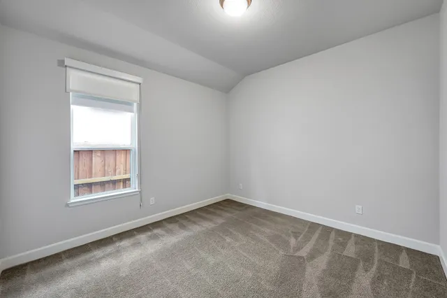 an empty room with closet and natural light