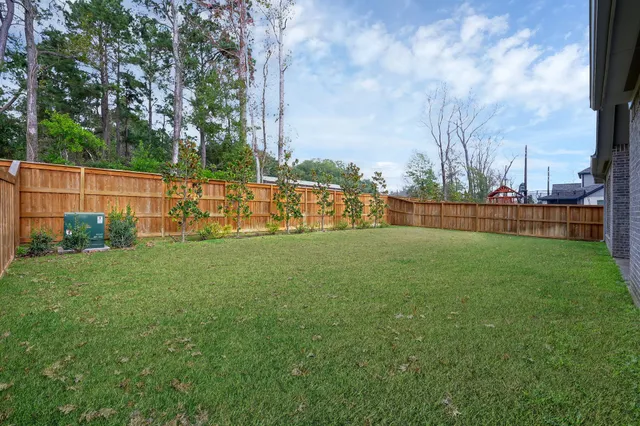 a view of a house with a big yard potted plants and large tree