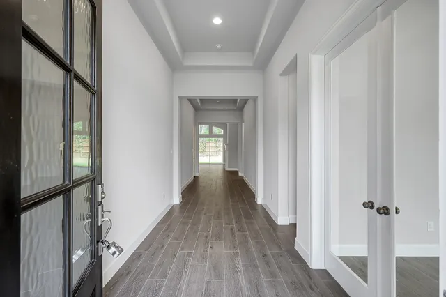 a view of a hallway with wooden floor and staircase