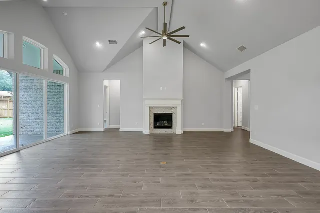 a view of an empty room with a fireplace and a window