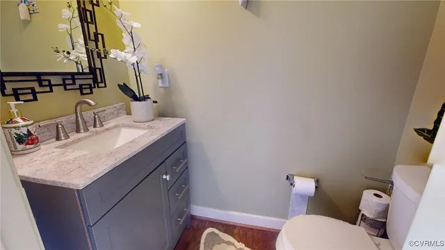 a bathroom with a granite countertop sink a toilet and a mirror