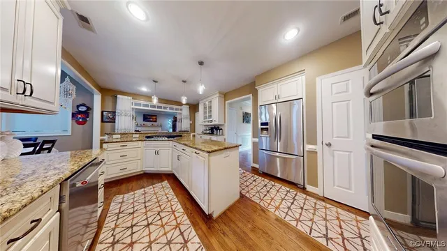 a kitchen with a refrigerator sink and cabinets