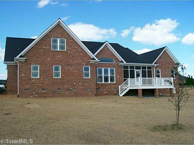 5628 Cape Fox Drive Oak Ridge, NC 27310 - Photo 2 of 16 Exterior Back. Trex deck off of screened in porch overlooks large backyard.