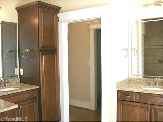 5628 Cape Fox Drive Oak Ridge, NC 27310 - Photo 11 of 16 Master Bath/Spa. Double vanities, walk around shower with glass block, custom tile design, linen cabinet.