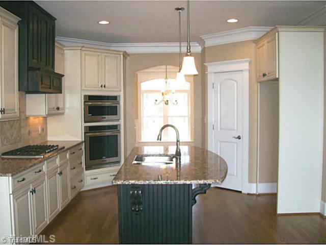 5628 Cape Fox Drive Oak Ridge, NC 27310 - Photo 6 of 16 Kitchen. Kitchen includes 36" gas cooktop, 30" oven, convection/microwave, custom hood, granite, hardwood floors, eat at counter and large pantry.