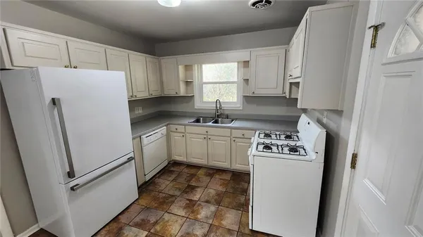 a kitchen with a white stove top oven and refrigerator