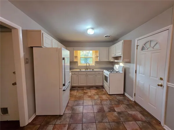 a kitchen with a refrigerator sink and cabinets