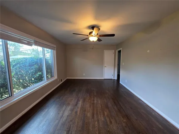 a view of a livingroom with wooden floor and a ceiling fan