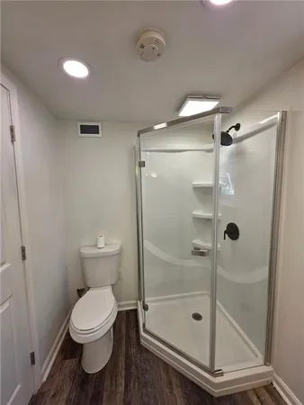 a bathroom with a shower a toilet and a sink
