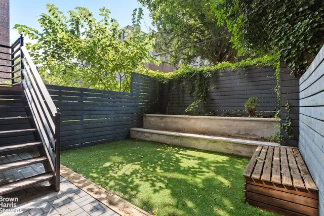 a view of backyard with wooden floor and fence