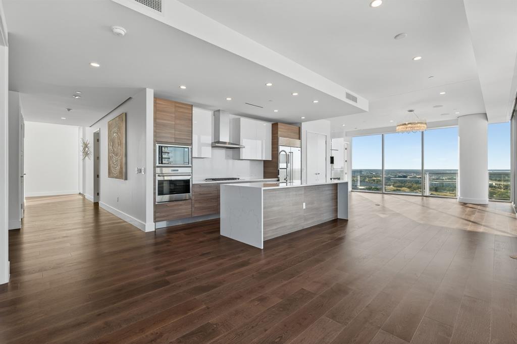 7901 Windrose Avenue, Unit 1701 Plano, TX 75024 - Photo 12 of 40 a large kitchen with stainless steel appliances refrigerator a stove top oven with wooden floors