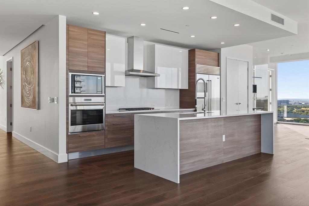 7901 Windrose Avenue, Unit 1701 Plano, TX 75024 - Photo 14 of 40 a kitchen with kitchen island white cabinets and stainless steel appliances