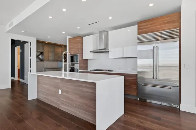 a kitchen with kitchen island white cabinets and stainless steel appliances