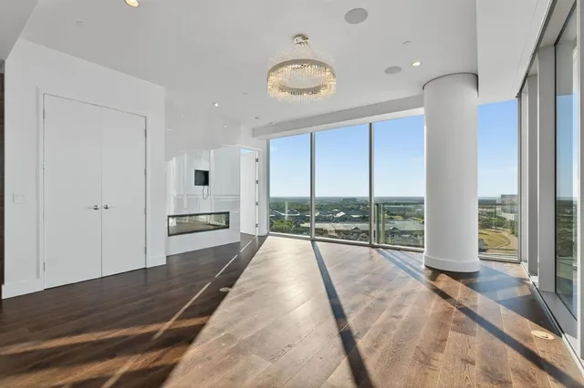 a view of a living room and floor to ceiling window with wooden floor