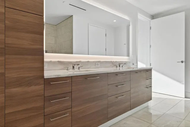 a bathroom with a double vanity sink a mirror and a