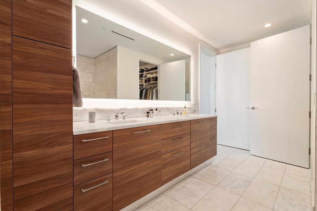 7901 Windrose Avenue, Unit 1701 Plano, TX 75024 - Photo 27 of 40 a bathroom with a double vanity sink a mirror and a