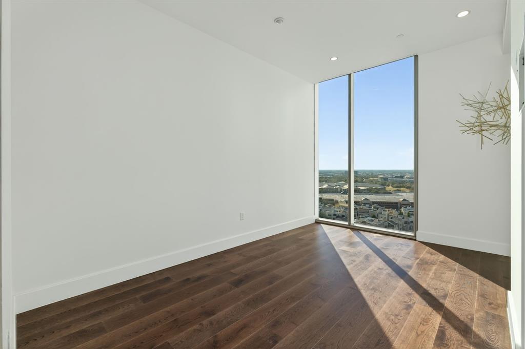 7901 Windrose Avenue, Unit 1701 Plano, TX 75024 - Photo 3 of 40 a view of an empty room with wooden floor and a window