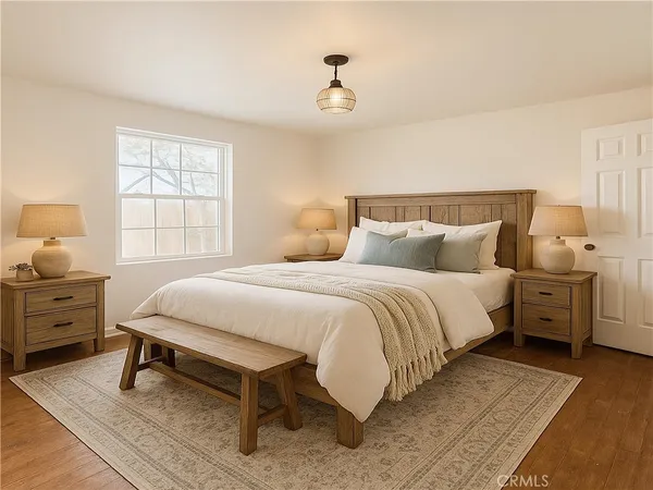 a bedroom with a bed and wooden floor