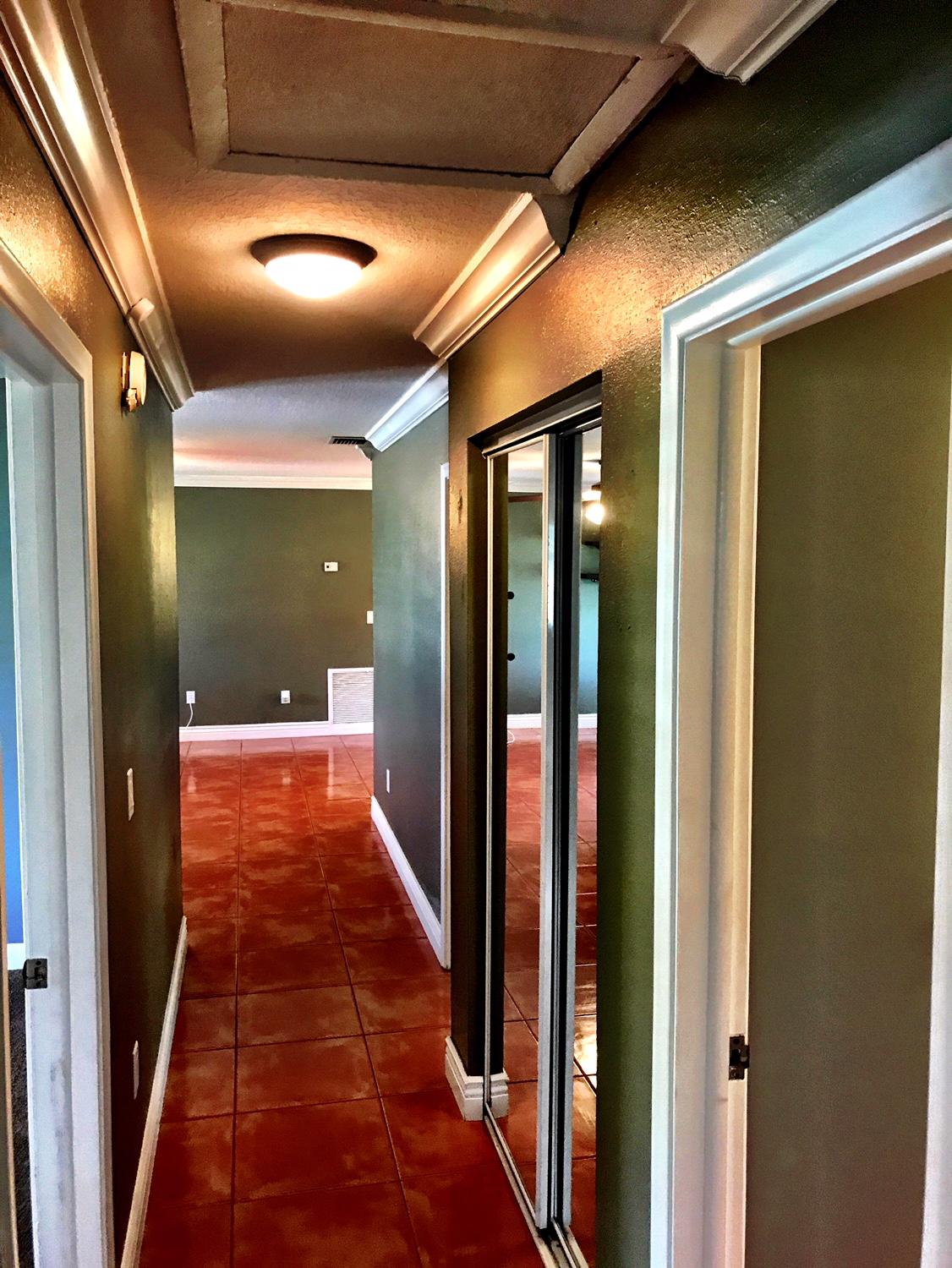 22250 Garrison Street Boca Raton, FL 33428 - Photo 15 of 26 a hallway with sitting area and chandelier