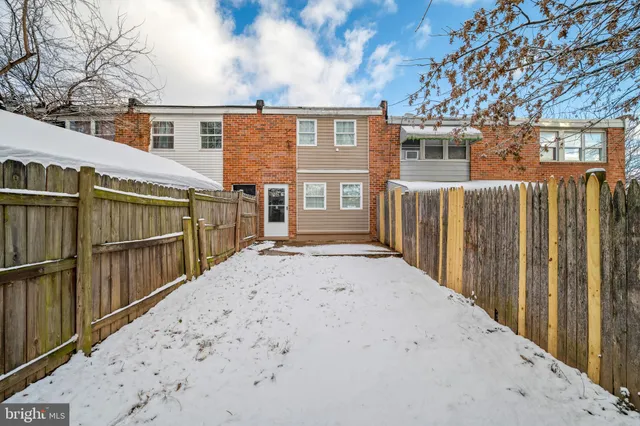 a view of a house with a wooden fence