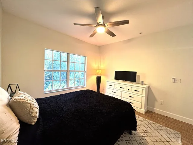 a bedroom with a bed and a flat tv screen on dresser