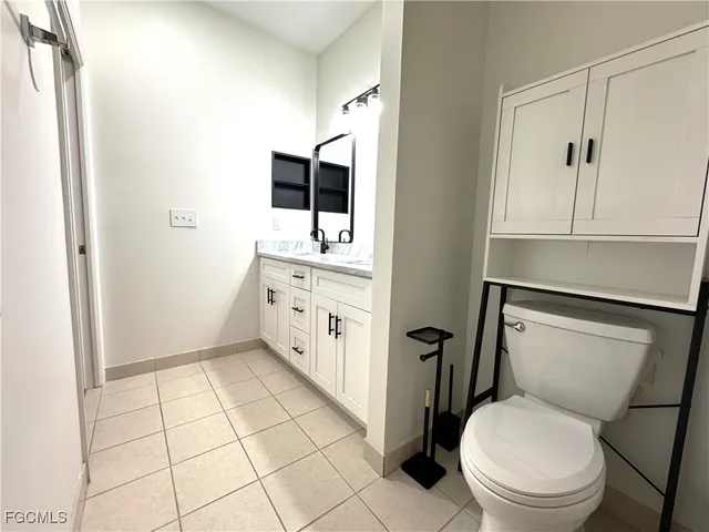 a bathroom with a toilet sink and mirror