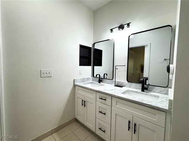 a bathroom with a granite countertop sink and a mirror