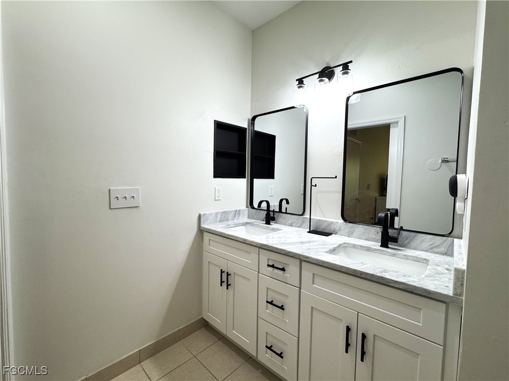 8423 Bernwood Cove Loop, Unit 410 Fort Myers, FL 33966 - Photo 19 of 39 a bathroom with a granite countertop sink and a mirror