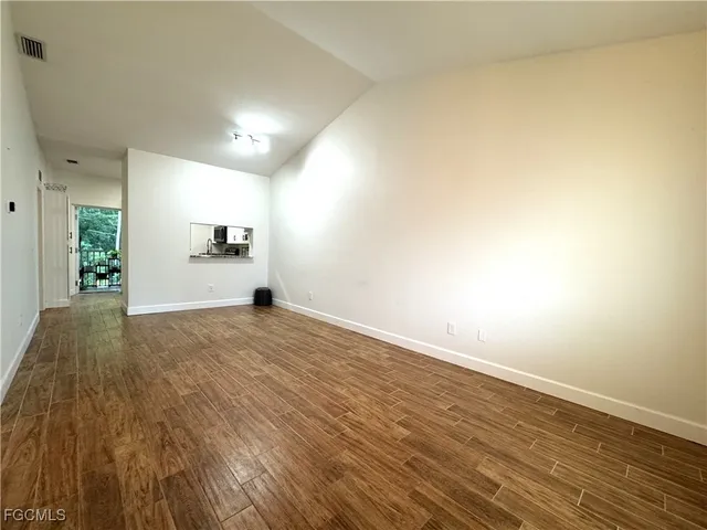 a view of empty room with wooden floor