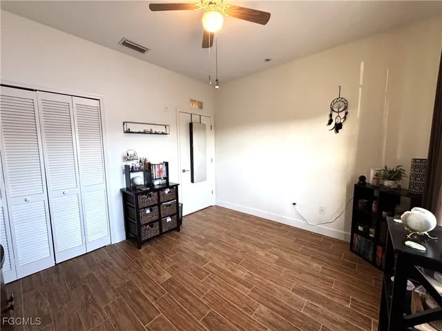 a view of a room with wooden floor closet and windows