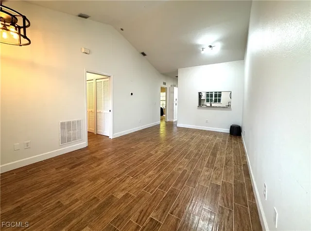 a view of an empty room with wooden floor
