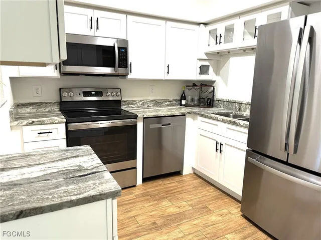 a kitchen with stainless steel appliances granite countertop a refrigerator stove and microwave