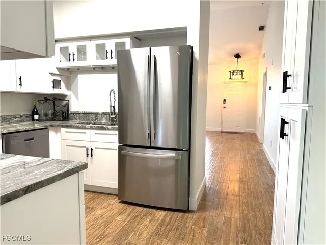 a kitchen with a refrigerator a stove top oven and cabinets