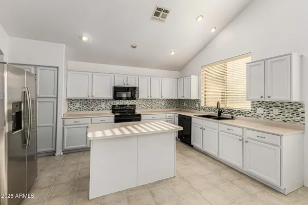a kitchen with cabinets stainless steel appliances and a counter space