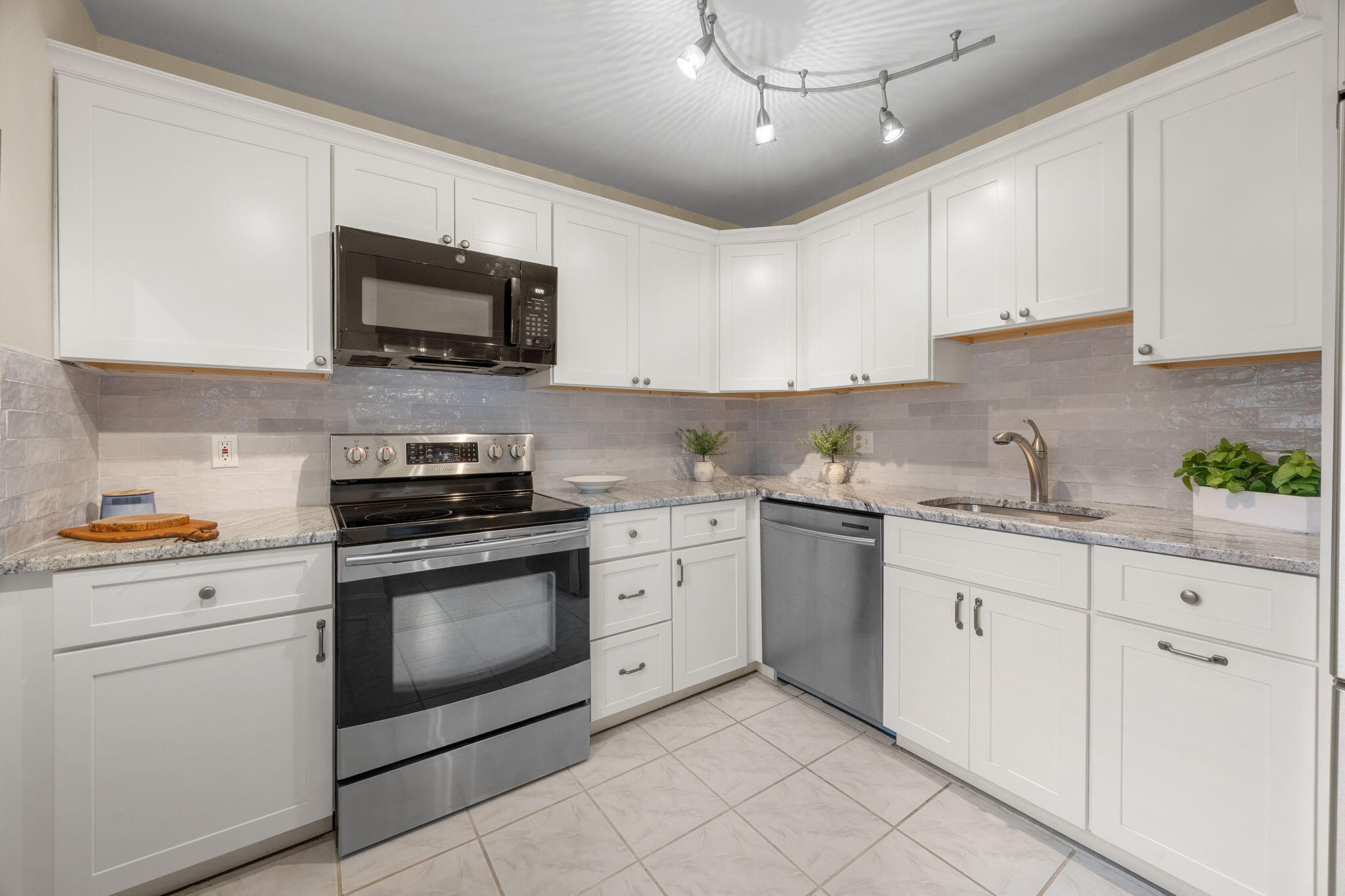 23 Landing Lane, Unit 23 Brewster, MA 02631 - Photo 11 of 33 a kitchen with white cabinets stainless steel appliances and sink