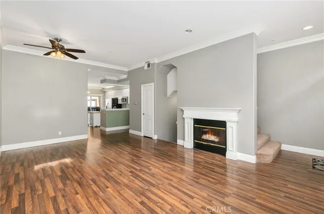 a view of a livingroom with wooden floor and a fireplace