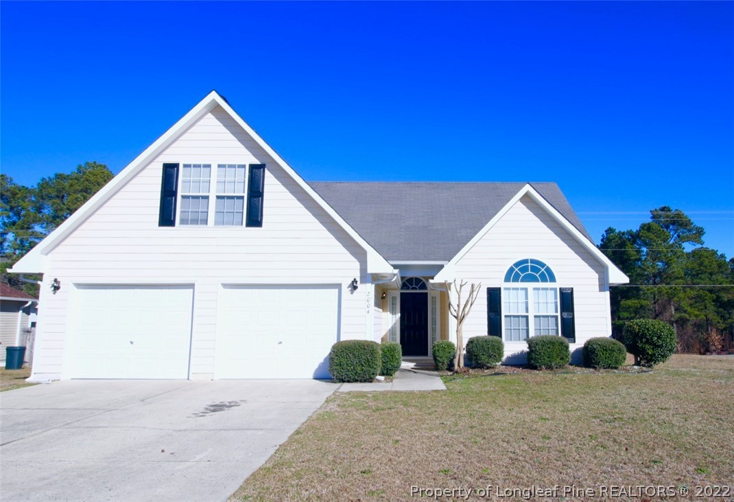 a view of a house with a yard and garage