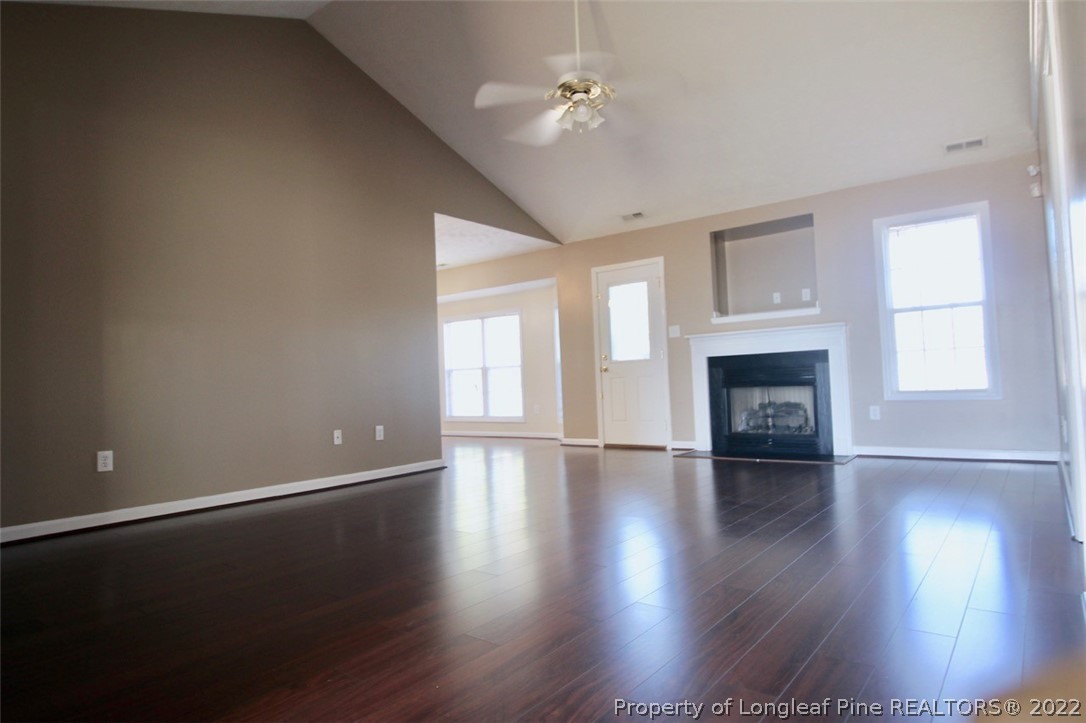 2004 Ivey Commons Road Fayetteville, NC 28306 - Photo 2 of 21 an empty room with wooden floor fireplace and windows