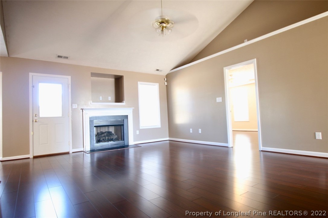 2004 Ivey Commons Road Fayetteville, NC 28306 - Photo 5 of 21 an empty room with wooden floor fireplace and windows